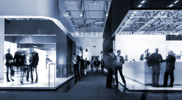 Exhibition hall at an international trade fair with visitors at company stands